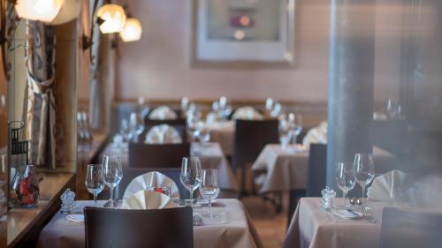 a restaurant with white tables and chairs with wine glasses at Hotel Krone Unterstrass in Zürich