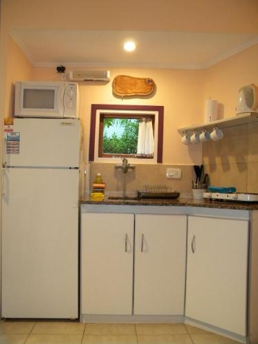 a kitchen with a white refrigerator and a microwave at Casa los Tilos in Valeria del Mar