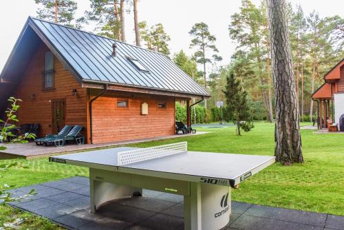 a ping pong table in front of a tiny house at Vacation Home Mezsargi in Pape