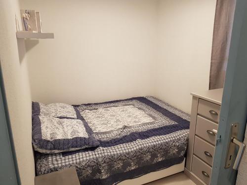 - une petite chambre avec un lit et une commode dans l'établissement Residence Beaupre, à Canet