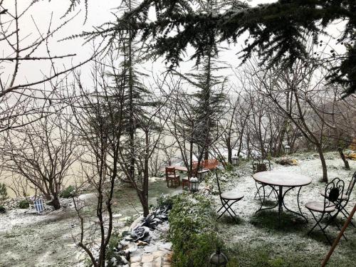 a picnic table and chairs in a snow covered yard at Zimer Al-Bayt in Mas'ade