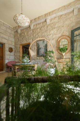 a living room with a stone wall and a table at Mresty Guest House in Al Mţullah