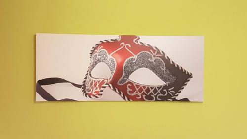 a picture of a masquerade mask on a wall at La Perla del Doge con Wellness & Spa uso esclusivo in Venice