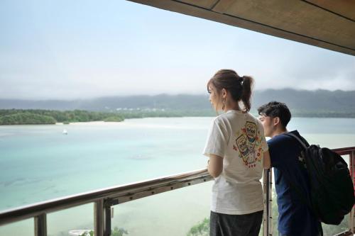 a man and a woman looking out at the water at The BREAKFAST HOTEL PORTO Ishigakijima in Ishigaki Island