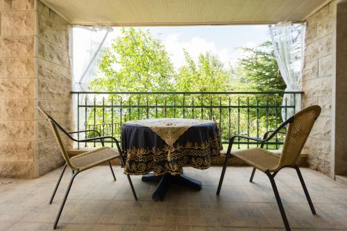 una mesa y sillas en un balcón con ventana en Mresty Guest House en Al Mţullah
