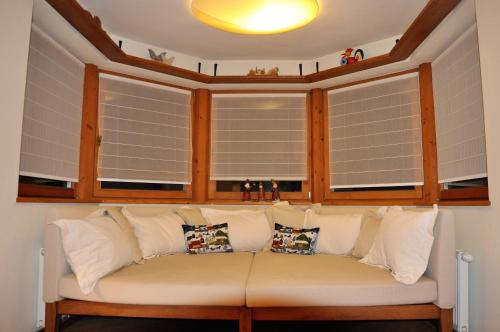 a white couch sitting in a room with windows at Haus Treffer in Kirchdorf in Tirol