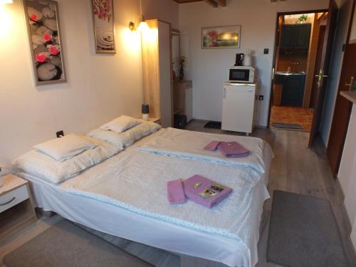 a bedroom with a bed with towels on it at Fehérló Vendégház & Restaurant in Bük