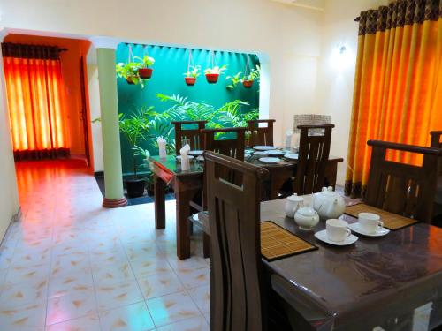 a dining room with a table and a fish wall at Stream View Family Resort in Dambulla