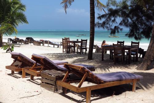 a group of chairs and tables on a beach at White Dream in Kiwengwa