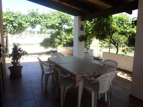 a wooden table and chairs on a patio at Residenza agrituristica Santa Lucia con piscina in Alghero