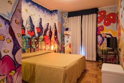 1 dormitorio con 1 cama con una pintura en la pared en La Locanda di Castromediano, en Castelmezzano