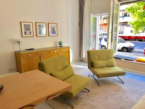 a living room with two chairs and a table and a window at Ladenwohnung in Kreuzberg mit Parkplatz in einer Tiefgarage in Berlin