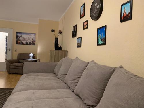 a couch in a living room with a clock on the wall at Apartment City Center Prestige in Dresden