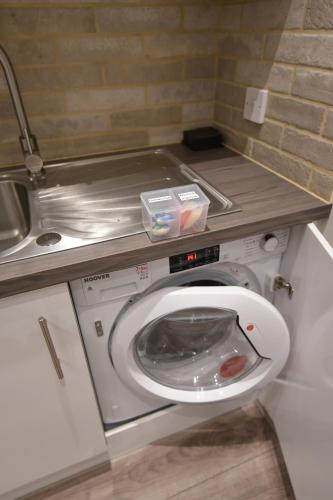a washing machine in a kitchen with a sink at Slateford House Apartment Ground Floor Main Door in Edinburgh