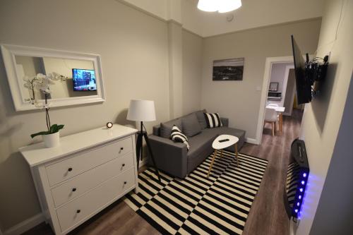 a living room with a chair and a dresser at Slateford House Apartment Ground Floor Main Door in Edinburgh