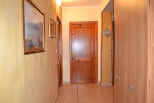 a hallway with a wooden door and a tile floor at Sa Marina in La Caletta