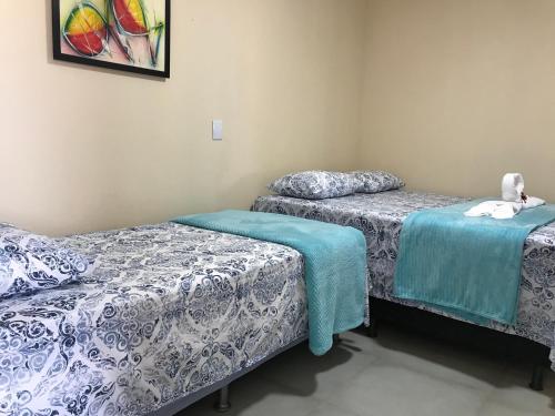 Dos camas en una habitación con sábanas azules y blancas. en CASA PE DE PEQUI, en Estivado