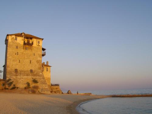 a lighthouse on a beach next to the ocean at Rooms Magnolia in Nea Vrasna