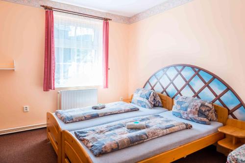 1 dormitorio con 2 camas y ventana en Penzion U Michala, en Prášily