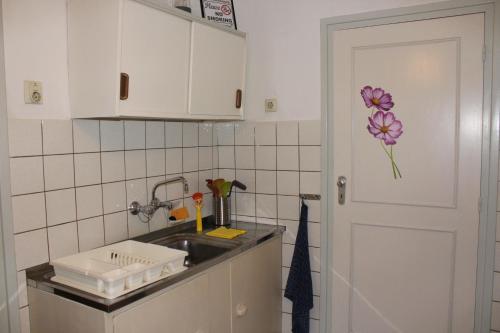 a kitchen with a sink and a flower on the door at appartement de Groote Peel in Nederweert