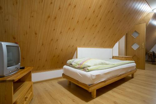 małą sypialnię z łóżkiem i telewizorem w obiekcie Pohulanka w Zakopanem