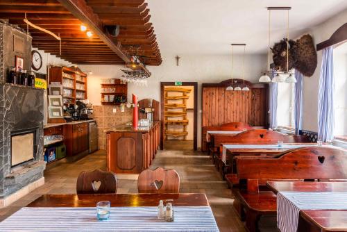 a restaurant with wooden tables and chairs in a room at Penzion U Michala in Prášily