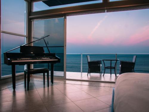 a piano in a room with a view of the ocean at Casa Caracol in Playa Coronado