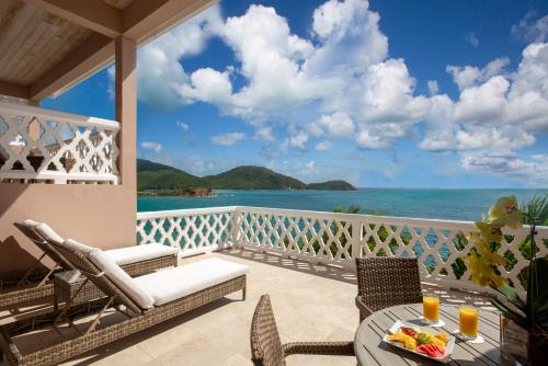 a balcony with a table and chairs and the ocean at Curtain Bluff - All Inclusive in Old Road