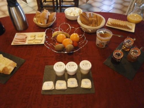 ein Tisch mit einer Schüssel Brot und einer Schale Obst in der Unterkunft auberge du pied des monts in Grivy-Loisy