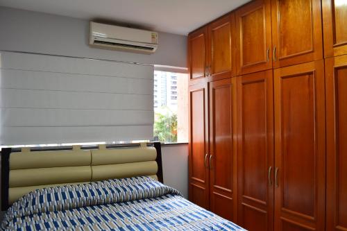 a bedroom with a bed and wooden cabinets at Moradas Pará in Belém