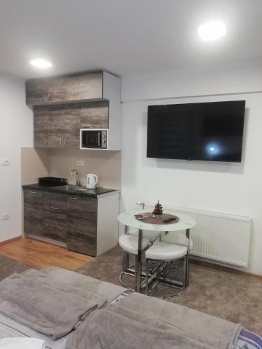 a living room with a table and a kitchen at Apartman Centar 1 in Užice