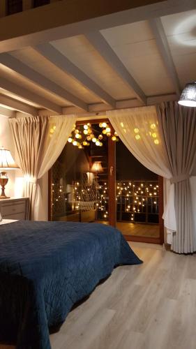 a bedroom with a bed with curtains and a window at Rasos Vila in Palanga