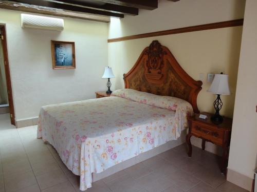 a bedroom with a bed and two lamps on tables at Hotel Hacienda Flamingos in San Blas