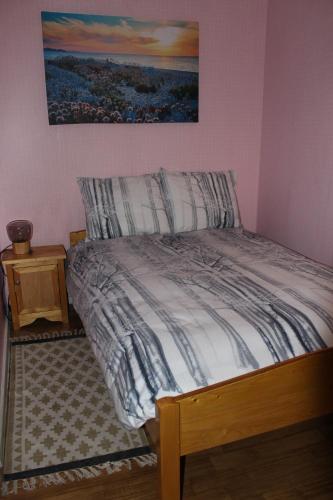 a bed in a bedroom with a picture on the wall at appartement de Groote Peel in Nederweert