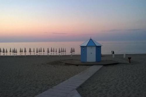 a blue shack sitting on the beach at sunset at Gli Ulivi Rosamarina Ostuni in Rosa Marina