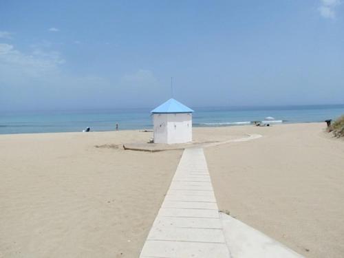 a building on a beach with the ocean in the background at Gli Ulivi Rosamarina Ostuni in Rosa Marina