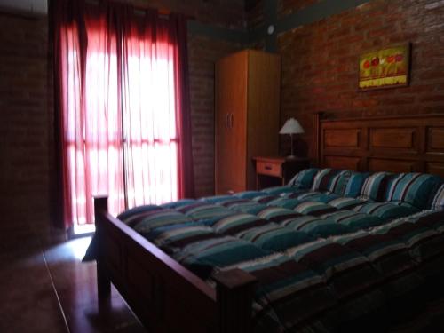 1 dormitorio con 1 cama grande y ventana en Rincón del Valle en Mina Clavero