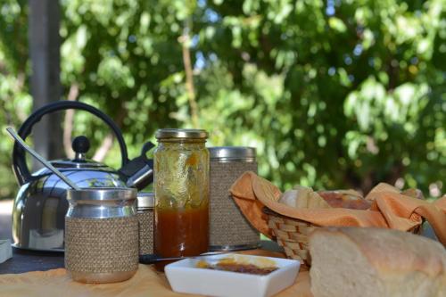 a table with bread and jam and a tea kettle at Casita Rural Los Abuelos in San Rafael