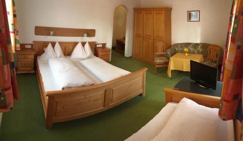 sypialnia z 2 łóżkami, kanapą i telewizorem w obiekcie Gästehaus Kübler w mieście Haus im Ennstal