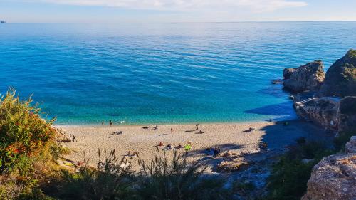 a group of people on a beach near the water at Apartamentos Latin in Nerja