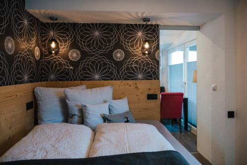 朗根費爾德的住宿－Apart Julia，一间卧室设有一张大床和一堵图案的墙壁