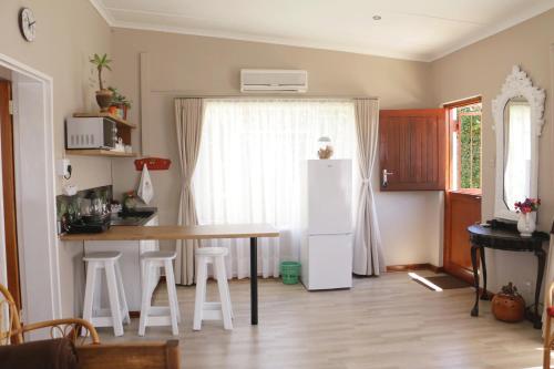 a kitchen with a table and a white refrigerator at Aalkie's Dream in Swellendam