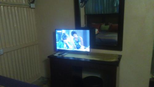 a television sitting on a table in front of a mirror at El Conde de Villa Rosa in Salado