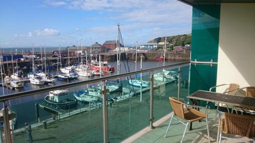 a balcony with a marina with boats in the water at Harbourside Apartment in Whitehaven
