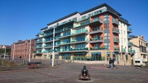 a large apartment building in front of a parking lot at Harbourside Apartment in Whitehaven