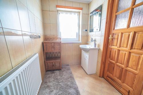 a bathroom with a sink and a toilet and a door at U Gałuse in Jurgów