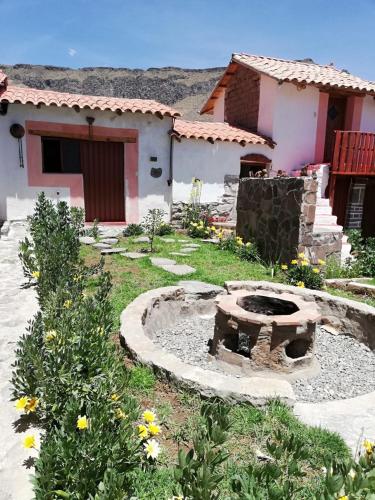 a garden with a fire pit in front of a house at Wayra Wasi in Coporaque