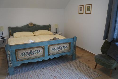 a bedroom with a blue bed and a chair at Ausblick Appartements mit Lungaucard in Sankt Michael im Lungau