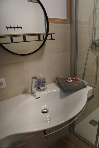 a bathroom sink with a mirror and a shower at Ausblick Appartements mit Lungaucard in Sankt Michael im Lungau