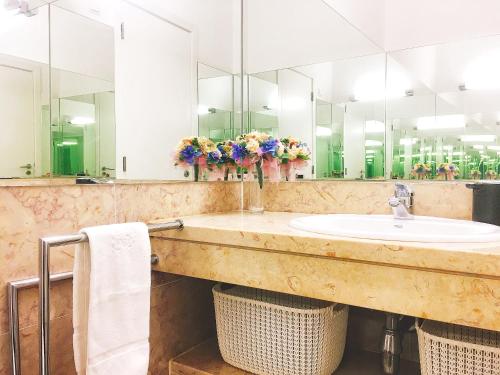 La salle de bains est pourvue d'un lavabo et d'un grand miroir. dans l'établissement Baixa Chiado Áurea Apartment, à Lisbonne
